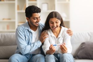 Joyful Indian couple celebrating pregnancy after PCOS infertility treatment